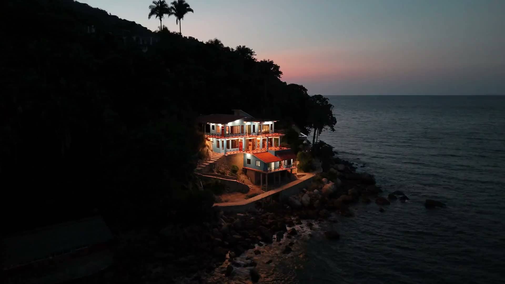 Casa Altamar lit up at dusk on the point of Yelapa Bay